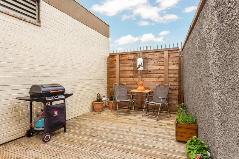 The enclosed side garden is mainly laid to lawn and chips with decking area.