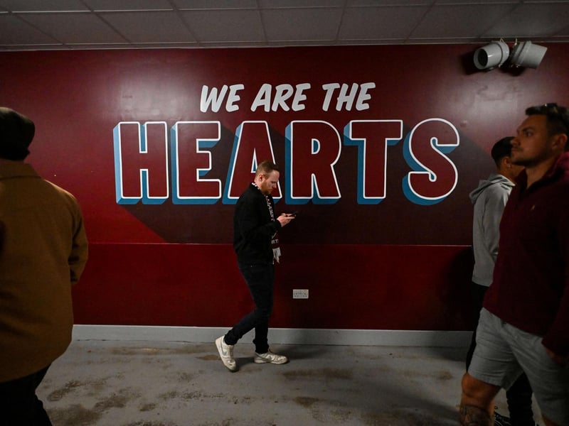 A Hearts fan walks past a slogon painted on the wall during the match  (Photo by ANDY BUCHANAN / AFP via Getty Images)