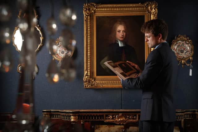 Dominic Somerville-Brown in front of a rare portrait of Jonathan Swift. The painting thought to be the earliest likeness of Gulliver's Travels author Jonathan Swift is to be sold in an online auction. (Photo credit: Stewart Attwood/Lyon & Turnbull/PA Wire)