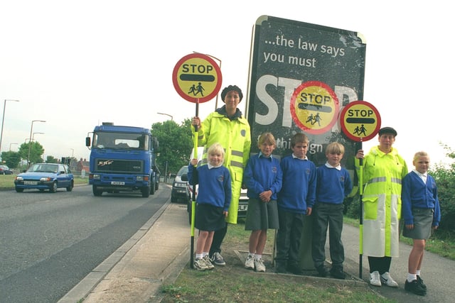 A new poster campaign was launched to try to stop drivers being agressive near school crossings. Children from St Theresa's school, Prince of Wales Road, pose with lollipop ladies on the busy road in 1999