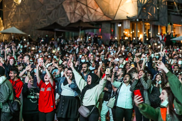 People are seen cheering and celebrating as they bring in the New Year at Federation Square during New Year's Eve celebrations on January 1, 2021 in Melbourne, Australia. Celebrations look different this year as COVID-19 restrictions remain in place due to the ongoing coronavirus pandemic.