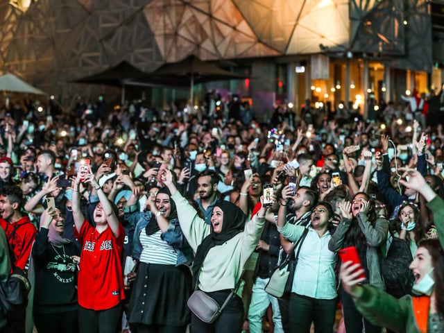 People are seen cheering and celebrating as they bring in the New Year at Federation Square during New Year's Eve celebrations on January 1, 2021 in Melbourne, Australia. Celebrations look different this year as COVID-19 restrictions remain in place due to the ongoing coronavirus pandemic.