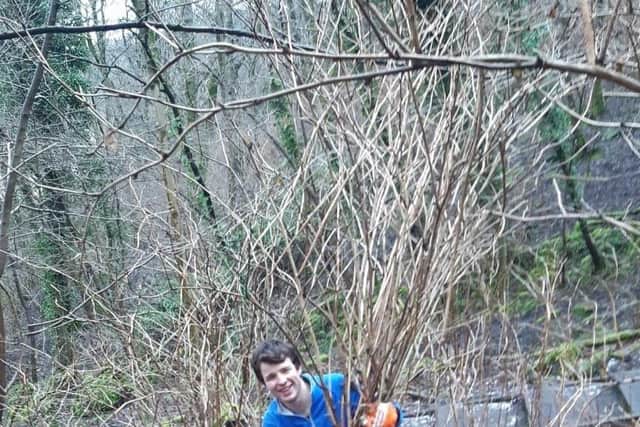 Fraser Dunmore, 20, clearing Samonberry from Corstorphine Hill in Edinburgh.