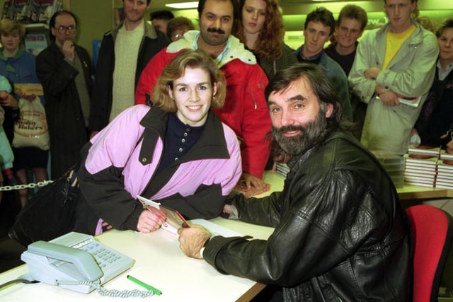 Football legend George Best (with beard), in John Menzies Edinburgh on book signing, promoting his autobiography The Good the Bad and the Bubbly in December 1990. George signs a book for fan Gayle Reynolds.