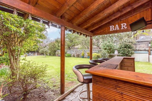 The property's back garden includes this desirable covered bar area, perfect for having friends round.