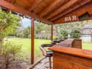 The property's back garden includes this desirable covered bar area, perfect for having friends round.