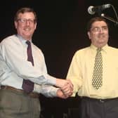 Ulster Unionist leader David Trimble, left, and SDLP leader John Hume shake hands on stage during a concert to promote the yes vote in the referendum on the Good Friday Agreement (Picture: Gerry Penny/AFP via Getty Images)