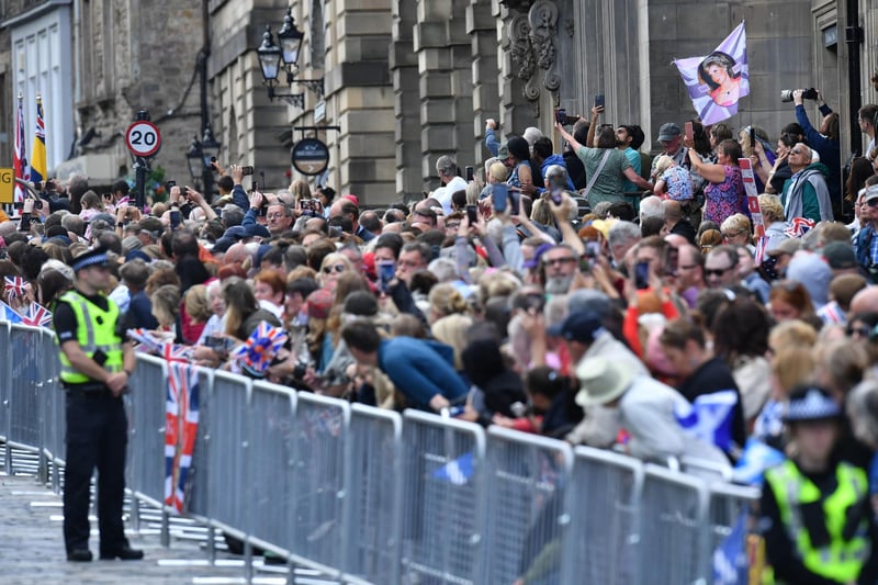 Members of the public lined the Royal Mile to watch the procession to St Giles' Cathedral ahead of the National Service of Thanksgiving and Dedication for King Charles III and Queen Camilla.