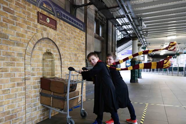 Twins Harris and Ethan Christie, both 9, pose with the Harry Potter Platform 9 ¾ trolley that was unveiled today at Edinburgh Waverley train station.