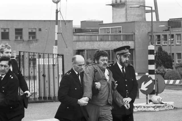 Police escort a miner away from outside Bilston Glen colliery during the strike  in June 1984.