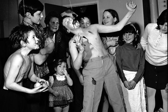 Children trying to catch treacle scones at the children's Hallowe'en party at Greenside Parish Church in Edinburgh, in November 1971.
