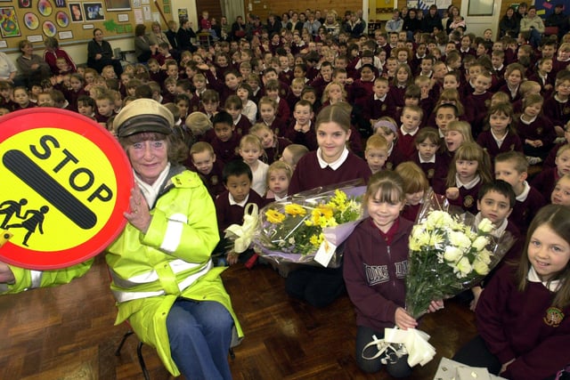 Lollipop lady Val Hutchinson, 60,  pictured with pupils at Woodhouse West Primary School in 2004