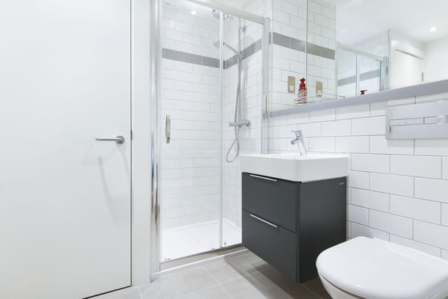 The stylish shower room comprises a wall-mounted vanity cabinet, back to wall WC and a shower. There is also a utility cupboard which houses a washing machine, which is included in the sale.