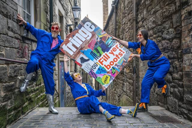 Cris Peploe, Claudia Cawthorne and Martha Haskins pose with a large-scale version of the Edinburgh Festival Fringe 2023 programme cover in Anchor Close. Picture: Jane Barlow/PA Wire