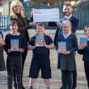 Local Taylor Wimpey Sales Executive Calum MacLean with Mrs Aileen McLean Depute Teacher and members of the P5 Eco Group at Queensferry Primary School celebrating their donation of £250 and Ecotastic Activity books.