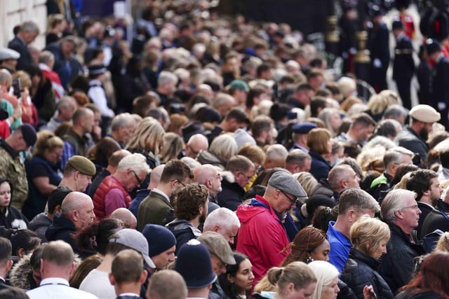 A crowd listens to the State Funeral Service of Queen Elizabeth II on Horse Guards Avenue in London, Monday Sept. 19, 2022. The Queen, who died aged 96 on Sept. 8, will be buried at Windsor alongside her late husband, Prince Philip, who died last year. (David Davies/Pool Photo via AP)