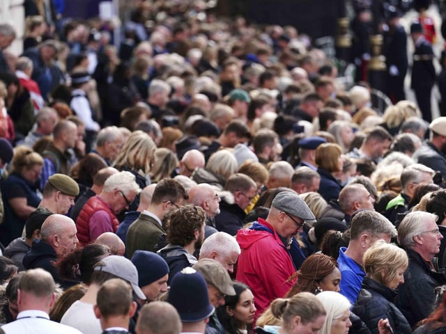 A crowd listens to the State Funeral Service of Queen Elizabeth II on Horse Guards Avenue in London, Monday Sept. 19, 2022. The Queen, who died aged 96 on Sept. 8, will be buried at Windsor alongside her late husband, Prince Philip, who died last year. (David Davies/Pool Photo via AP)