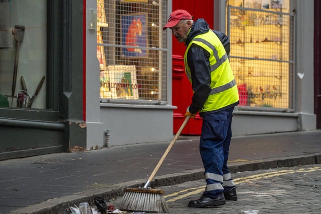 A waste worker sets about returning beautiful Victoria Street to its former glory after moutains of rubbish piled up. Photo: Lisa Ferguson