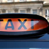 An illuminated taxi sign on a black hackney cab in the West End of Edinburgh. Drivers have hit out over a delay in Covid support payments