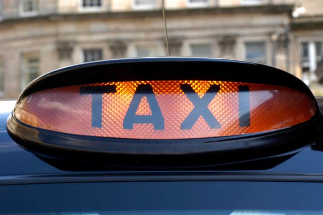 An illuminated taxi sign on a black hackney cab in the West End of Edinburgh. Drivers have hit out over a delay in Covid support payments