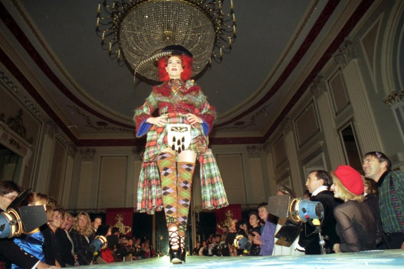A model wearing a tartan coat, mini kilt and sporran, strolls the catwalks as part of the Vivienne Westwood fashion show held in Edinburgh's Assembly Rooms in August 1993.