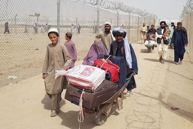 Afghan nationals carrying their luggage arrive into Pakistan at the Pakistan-Afghanistan border crossing point in Chaman on August 17, 2021. (Picture: AFP via Getty Images)