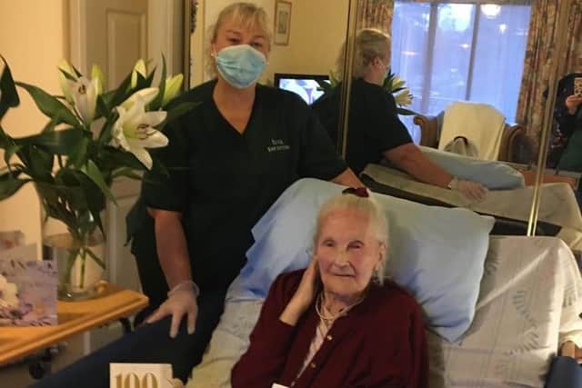 Mrs M in her home with carer Karen Dalrymple after receiving cards and flowers for her 100th birthday picture: supplied