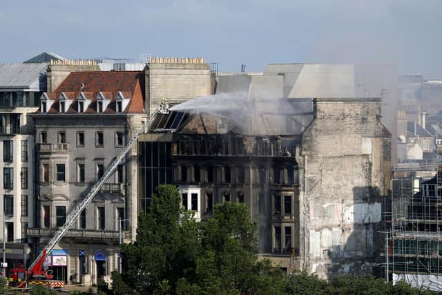 Firefighters put out the remains of a fire in the former Debenhams building on Princes Street on July 9.
