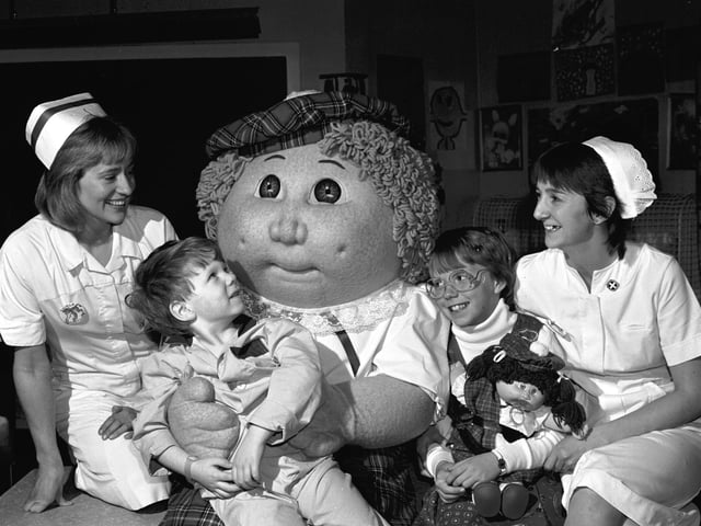 A giant Cabbage Patch Kid and 10-year-old Krisha Jacobs (with a Cabbage Patch doll) visited the Sick Children's Hospital in Edinburgh in October 1985.