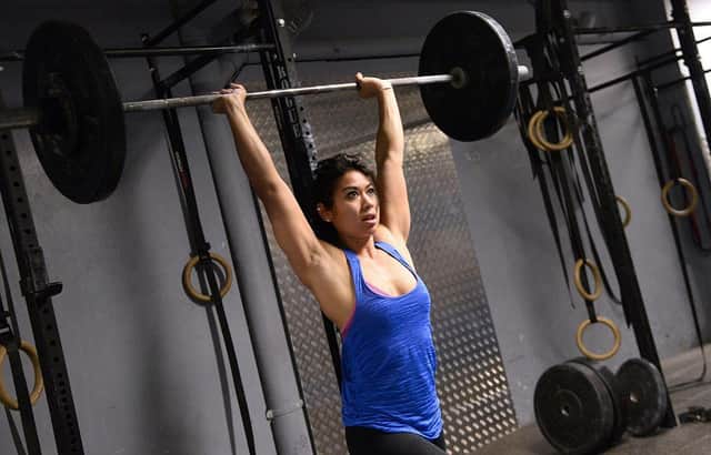 A woman lifts weight during crossfit training in a gym in Paris (Photo: BERTRAND GUAY/AFP via Getty Images)