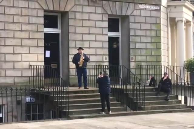 The saxophonist was playing to residents in Atholl Crescent in Edinburgh