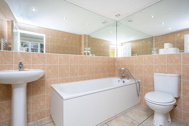 The family bathroom is partially tiled and finished with a white suite.