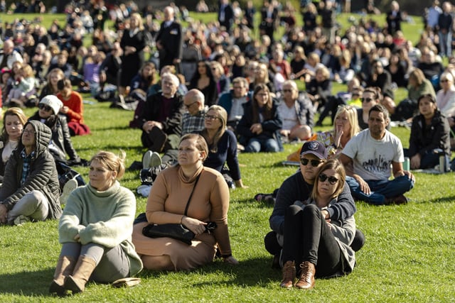 Members of the public watch Queen Elizabeth II's state funeral on a big screen in Holyrood park  in Edinburgh