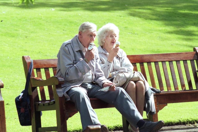 An elderly couple enjoy the Edinburgh sunshine and an ice cream cone, sitting on a Princes Street Gardens park bench in July 1993.