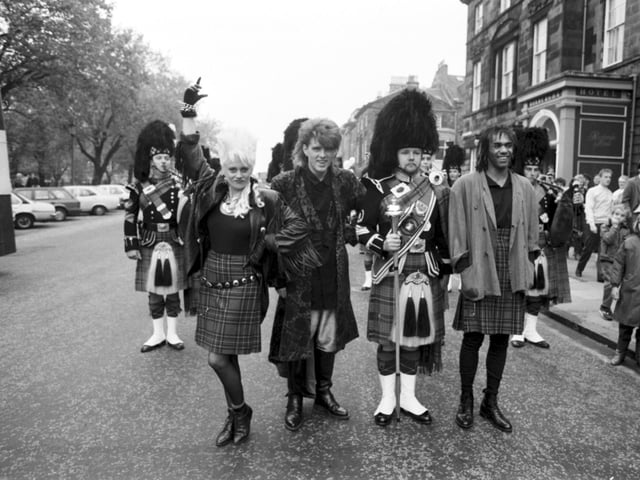 The Thompson Twins and a piper at the opening of the new HMV music store in Princes Street in October 1985.