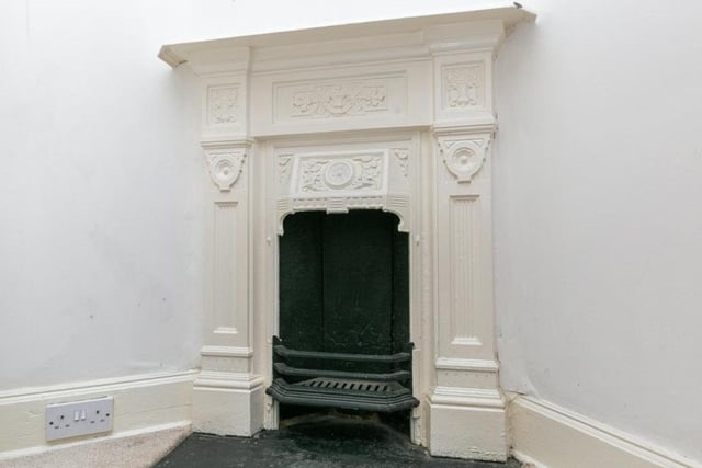 The property's period features include this original fireplace in one of the bedrooms.
