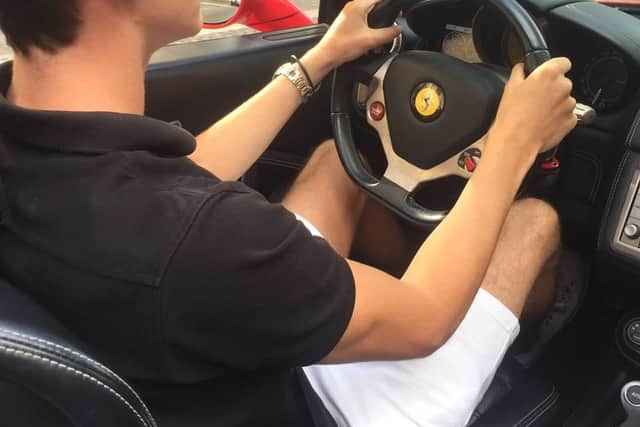 Wannabe entrepreneur Anderson behind the wheel of a Ferrari.