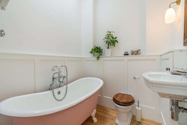 This flat's stunning three-piece bathroom is light and spacious, with an accent pink tub and shower over the bath. There is also storage space and a skylight which provides natural light.