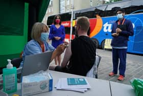 Scotland's deputy chief medical officer Dr Nicola Steedman watches as nurse Susan Pate administers a vaccination jab to Maurice Hickman, during a visit to a vaccination bus run by Scottish Ambulance Service and NHS Lothian at the Grassmarket in Edinburgh picture: Andrew Milligan