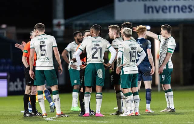 Hibs players surround referee David Munro at full-time after conceding an injury-time equaliser to Ross County.