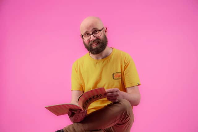 Gordon holding 'Bittersweet', a comic which explores his cancer diagnosis with dark humour.
