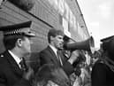 A policeman watches as Shareholders' Association chairman Ewan Stewart addresses the hundreds of angry Hibs fans who turned up at Easter Road football stadium after hearing Hearts chairman Wallace Mercer planned a takeover of their club in June 1990.
