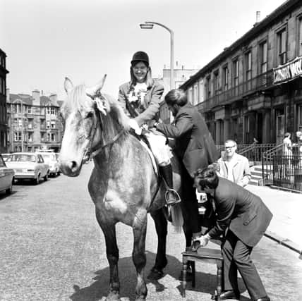 Robin Cook gets helped onto a horse at a photocall to poke fun at his Tory rival