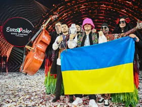 Members of the band "Kalush Orchestra" pose onstage with the winner's trophy and Ukraine's flags after winning on behalf of Ukraine the Eurovision Song contest in Turin. (Photo by Marco BERTORELLO / AFP) (Photo by MARCO BERTORELLO/AFP via Getty Images)