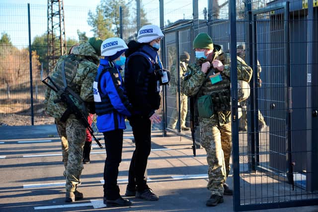 Observers from the Organisation for Security and Co-operation in Europe cross the checkpoint between the Kiev-controlled territory and occupied areas in the war-torn east of Ukraine (Picture: Evgeniya Maksymova/AFP via Getty Images)