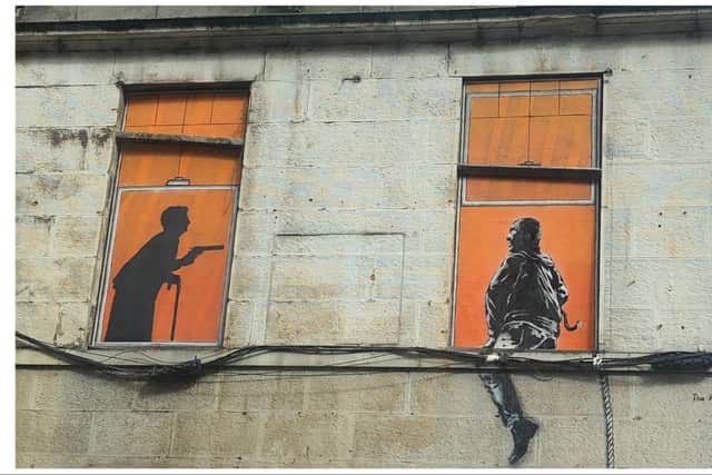 The image, depicting an eldery woman brandishing a gun at what looks like a bulgular, was spotted on a building wall in Duke Street, Leith. Photo: Russell Hunter
