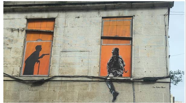 The image, depicting an eldery woman brandishing a gun at what looks like a bulgular, was spotted on a building wall in Duke Street, Leith. Photo: Russell Hunter