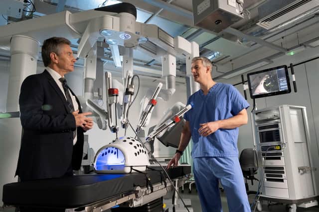 Professor Michael Griffin OBE, President of the Royal College of Surgeons of Edinburgh, and Mr Campbell Roxburgh, Senior Clinical Lecturer based at the University of Glasgow and Chair of the National Planning Robotic-Assisted Surgery Clinical Reference Group, alongside the robotic surgical equipment.