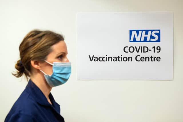 A nurse passes a sign indicating a Covid-19 Vaccination Centre. Picture: Dominic Lipinski/POOL/AFP via Getty Images