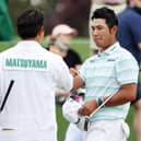 Hideki Matsuyama with his caddie after finishing on the 18th green in the third round of the Masters at Augusta National Golf Club. Picture: Kevin C. Cox/Getty Images.